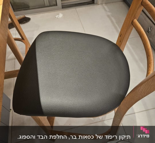 כיסא עם ריפוד עור שחור ליד שולחן עץ